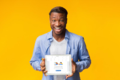 excited-man-holding-tablet-empty-screen-standing-studio-black-digital-over-yellow-background-m...png